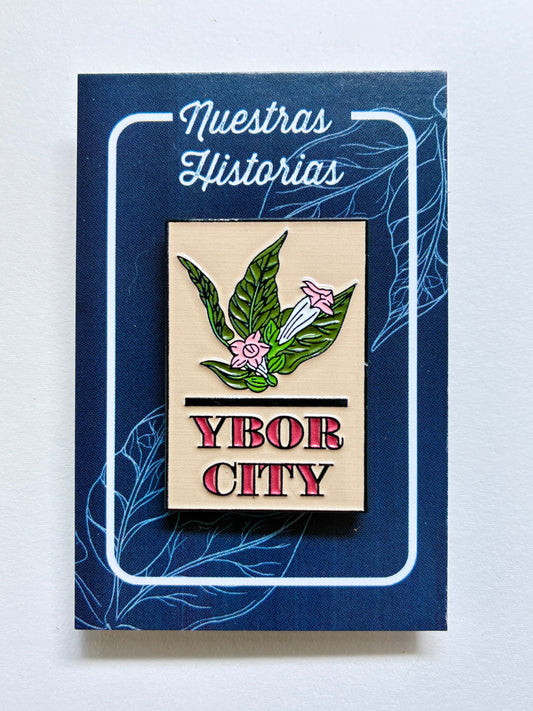 Enamel pin with tobacco leaf and flowers and the words Ybor City
